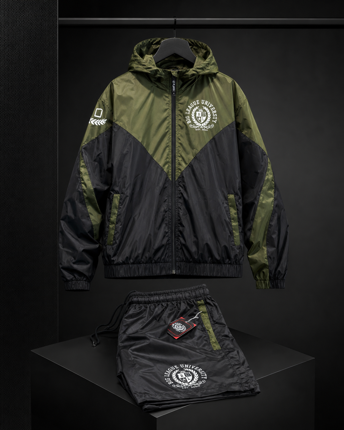 Olive and black Big League University windbreaker set displayed in a dark premium studio setting.